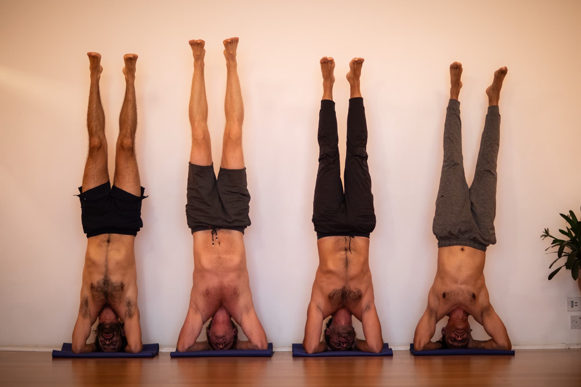 Men of the Vira group practising headstands together